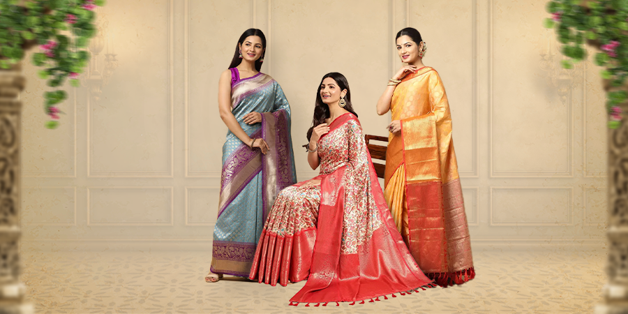 Elegant women in colorful traditional sarees posing indoors.