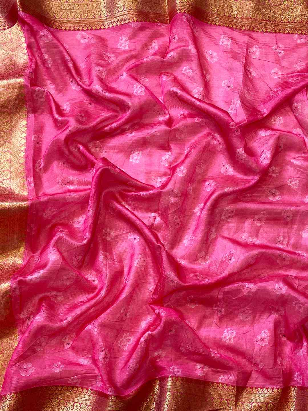 Close-up of pink and gold border Kota silk saree fabric