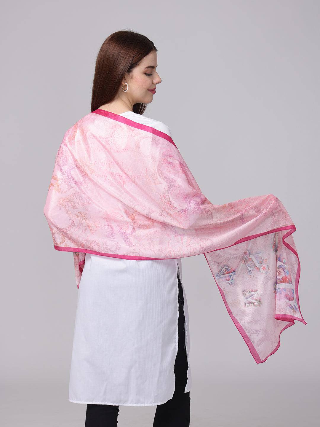 Back view of pink cursive script patterned scarf draped over shoulders.