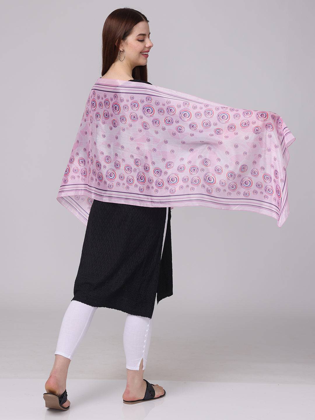 Side view of vibrant circular printed scarf in pink and purple.