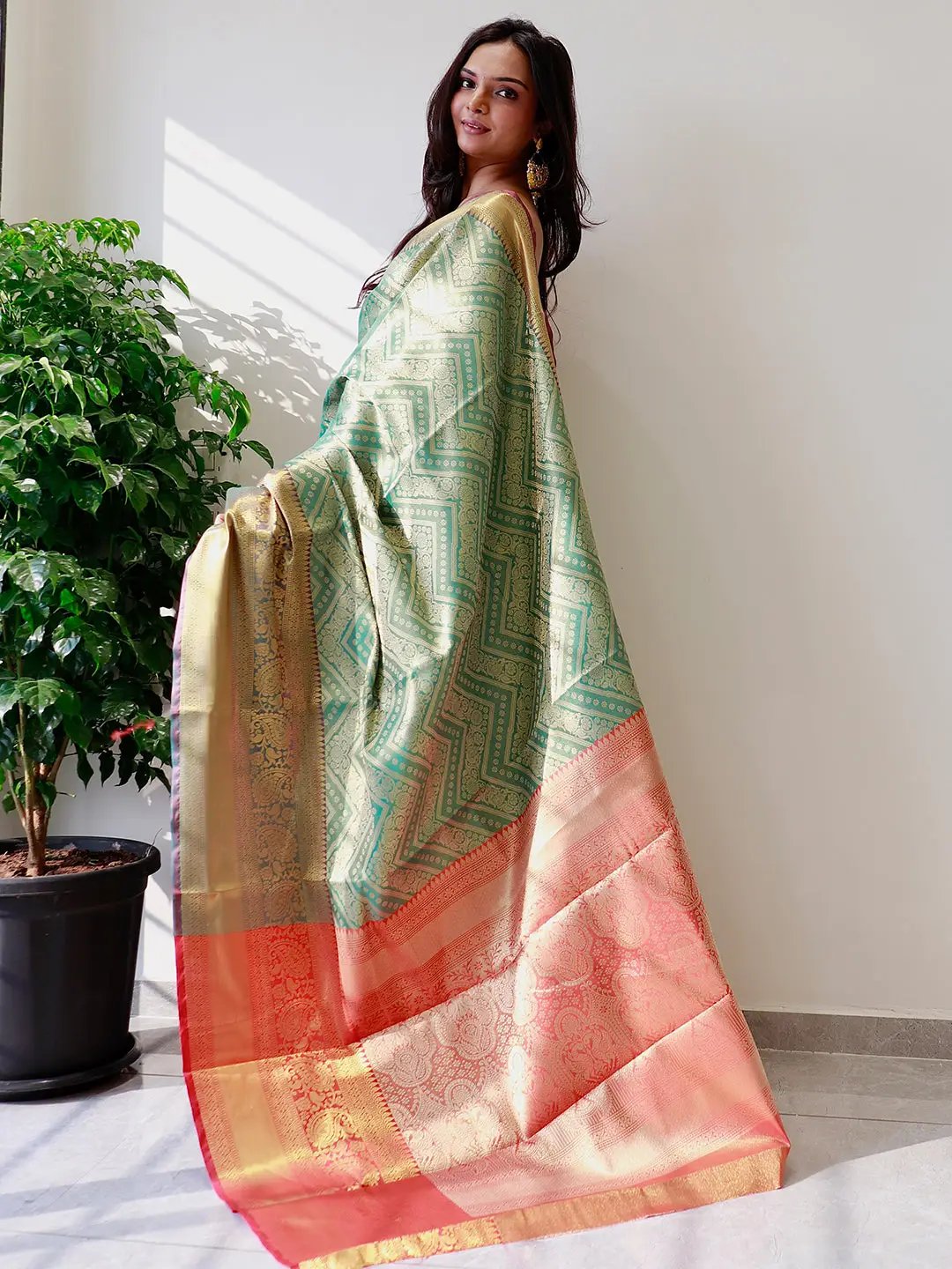 Side view of gold zari Kanjivaaram silk saree on model.