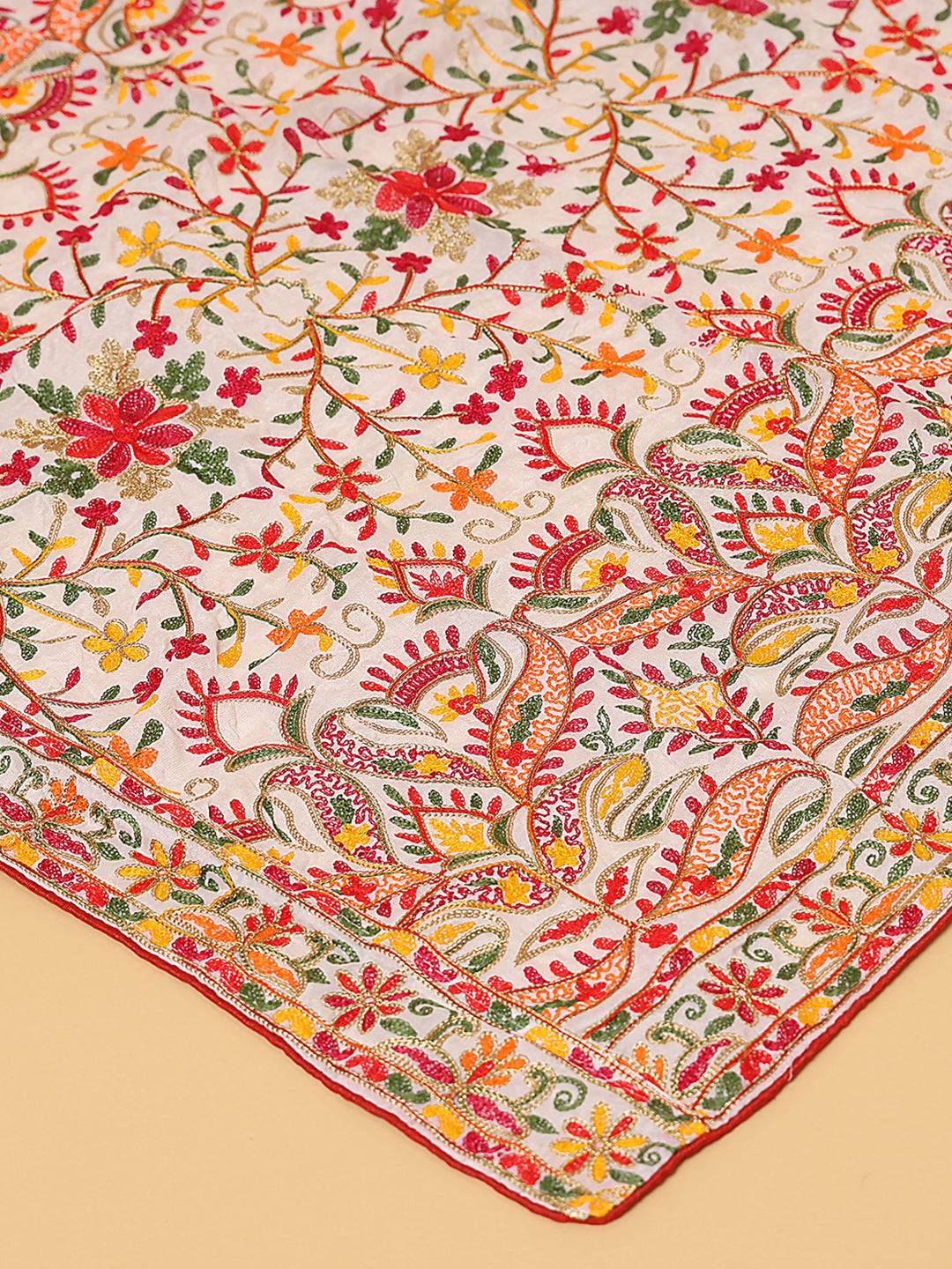 Close-up of colorful threadwork on white pashmina dupatta.