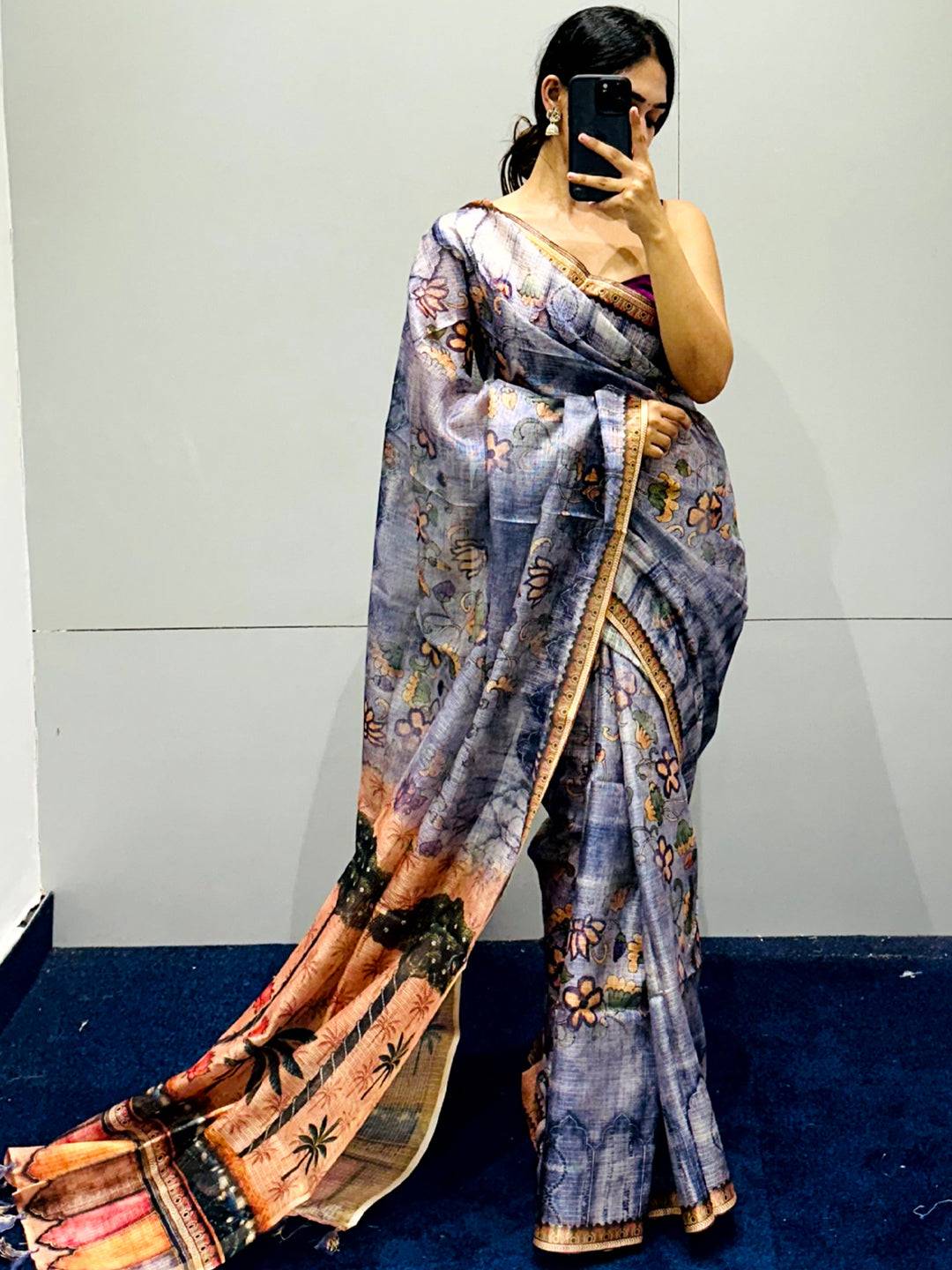 Woman posing in blue Kota Doriya silk saree with floral motifs.