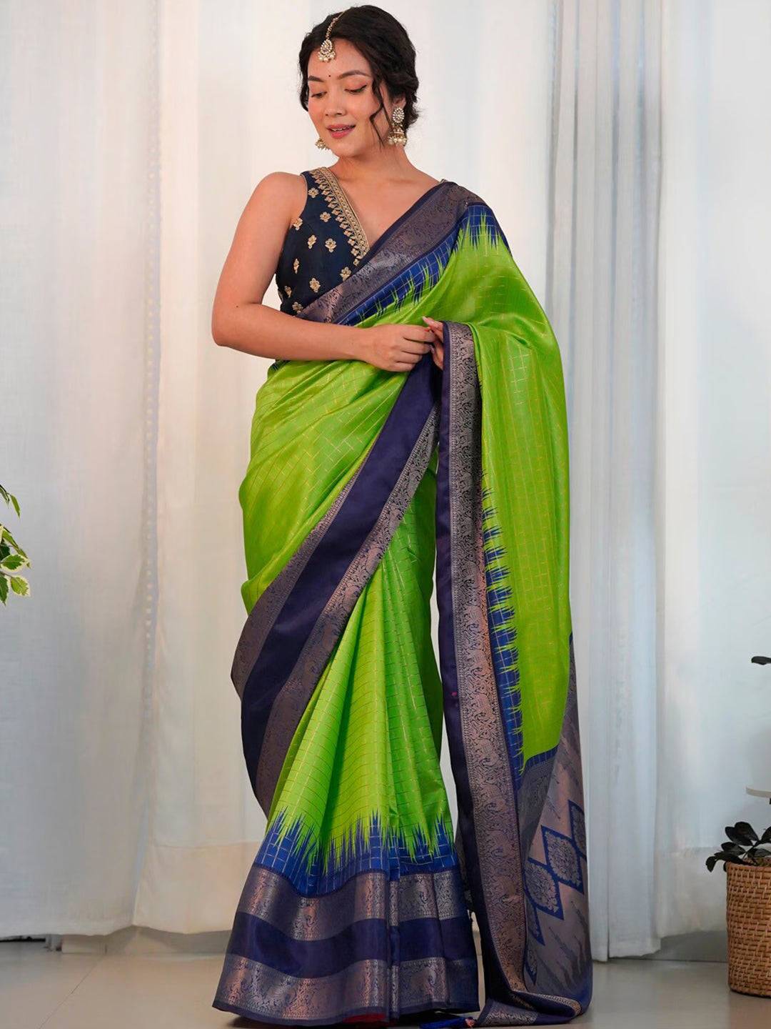 Model wearing green Banarasi silk saree with blue border