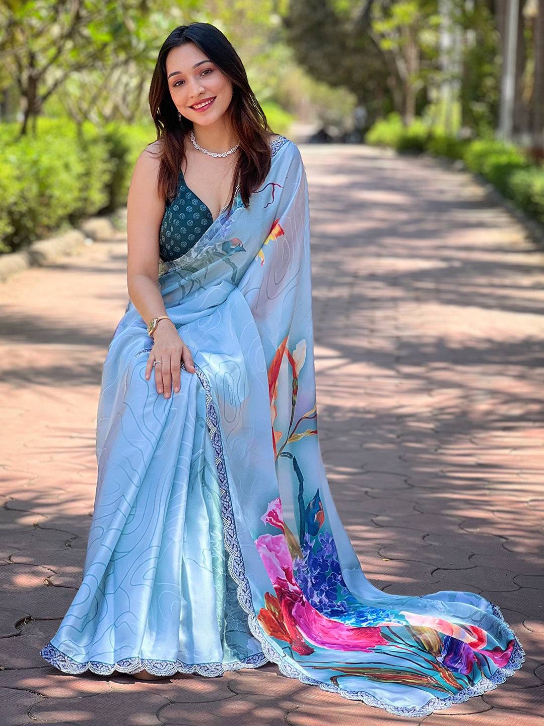 Sitting pose with light blue floral print satin saree