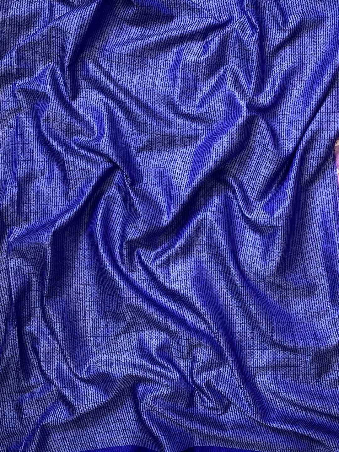 Close-up of blue silk fabric with textured Bandhej pattern.