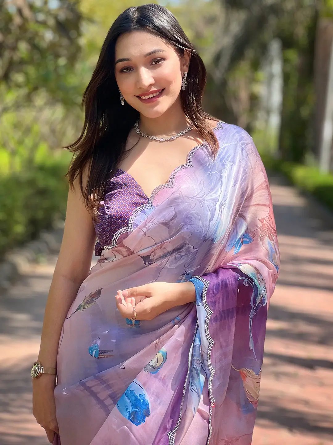 Lavender satin georgette saree with floral print, model smiling.