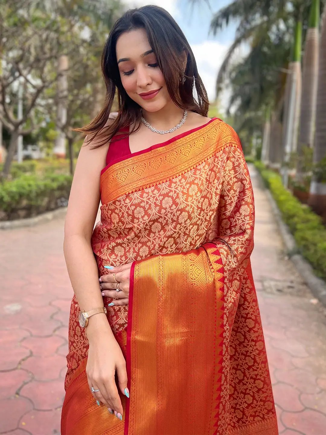 Elegant orange gold tissue saree with detailed jacquard work.