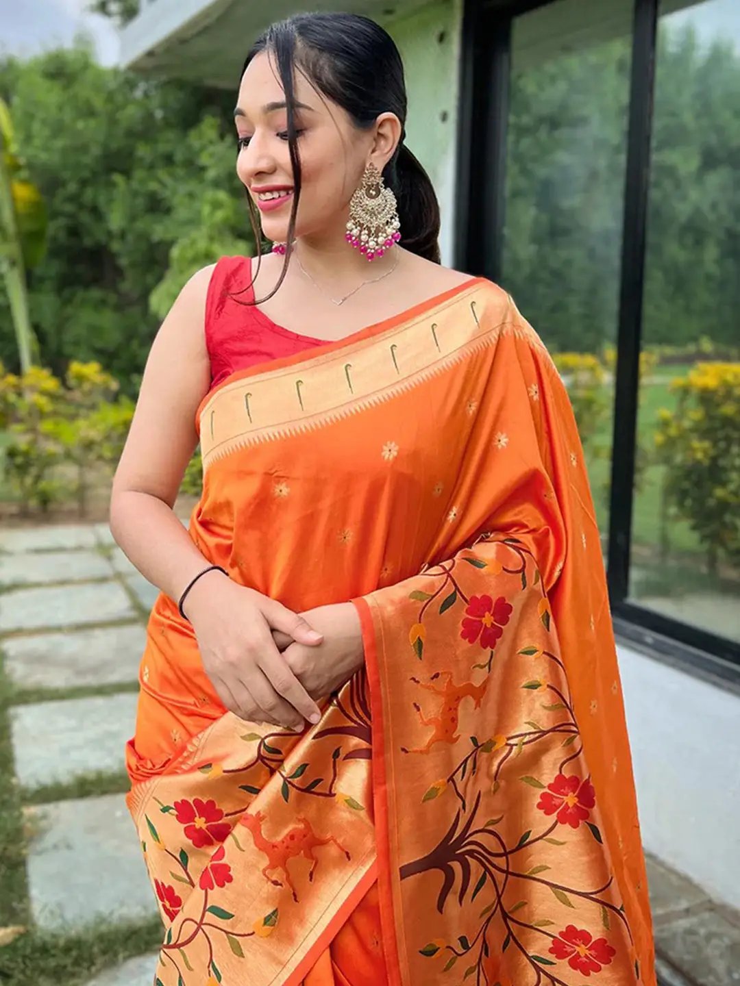 Close-up of orange Paithani saree with intricate floral border