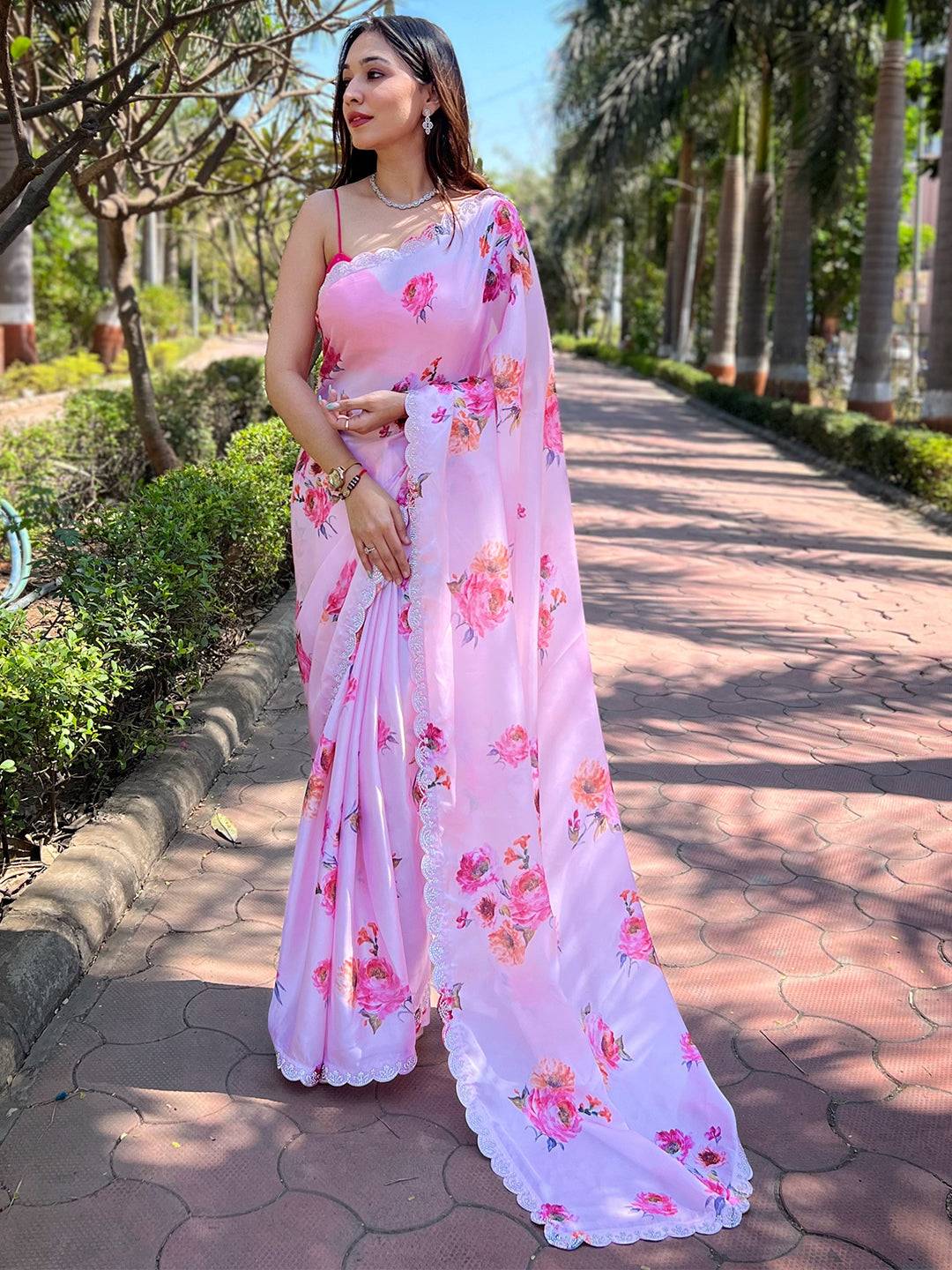 Elegant pink georgette saree with floral design and zircon border