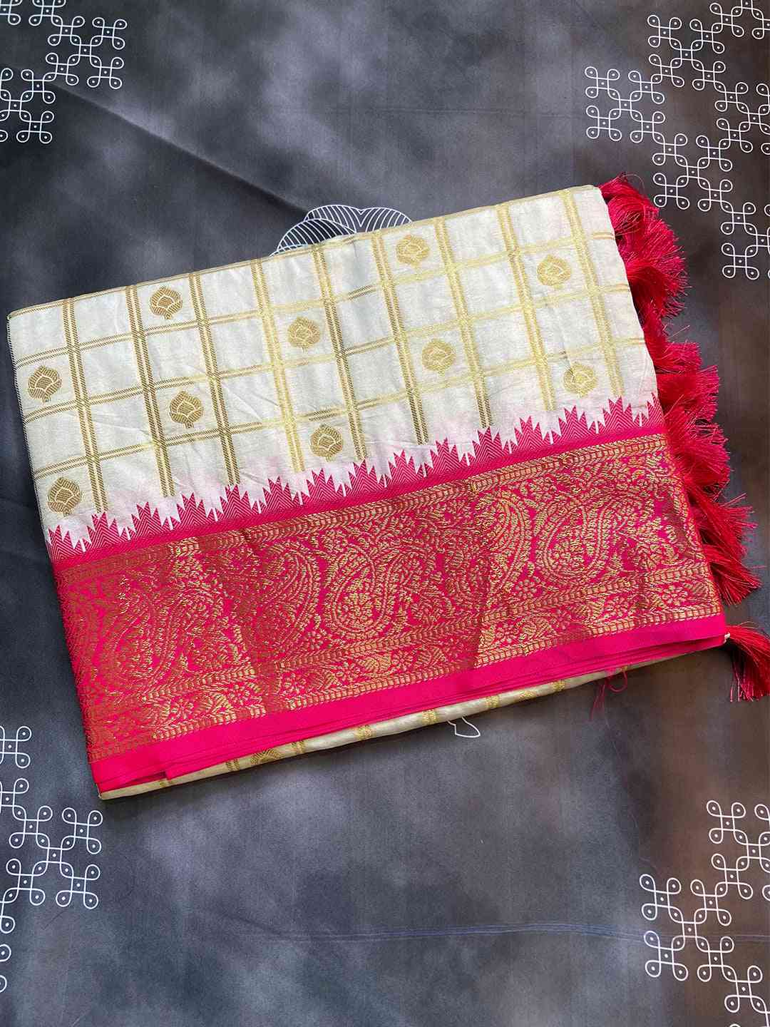 Folded Gadwal saree highlighting pink temple border design.