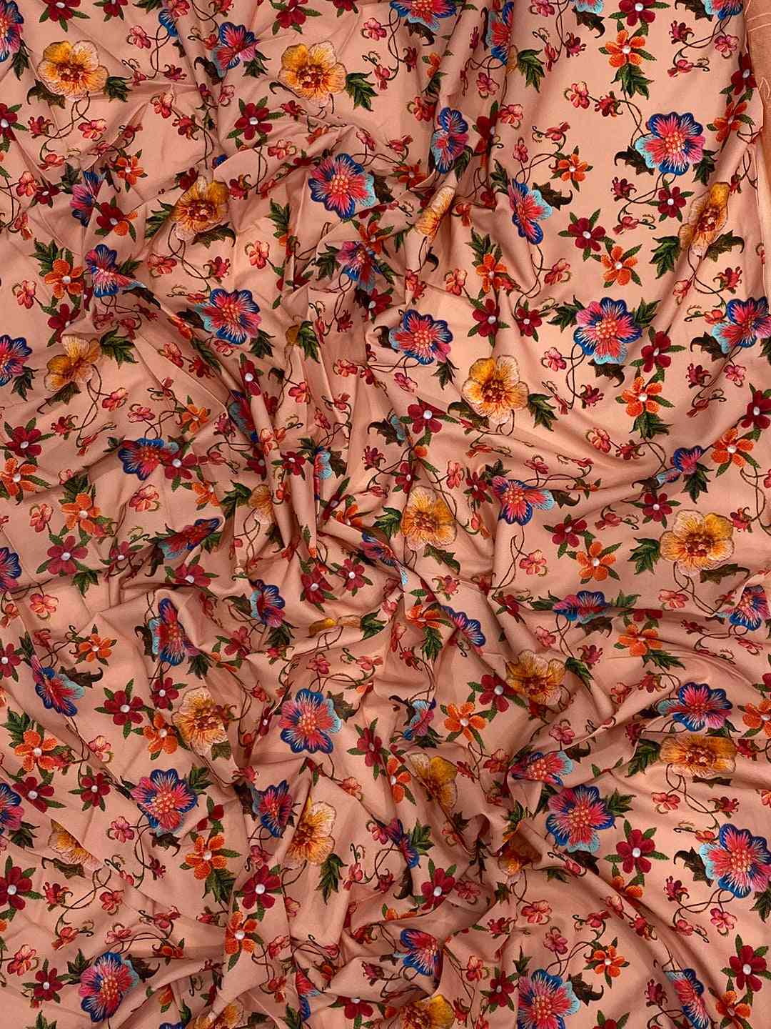 Close-up of floral embroidered chiffon satin fabric.
