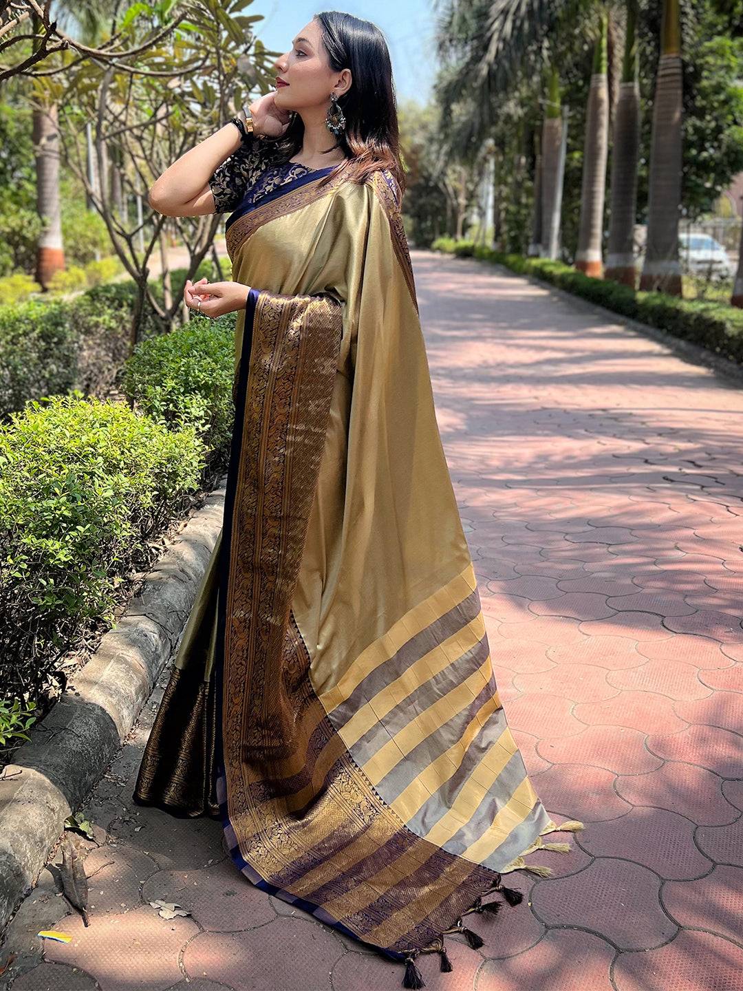 Model showcasing olive Kanjivaram saree with rich patterns