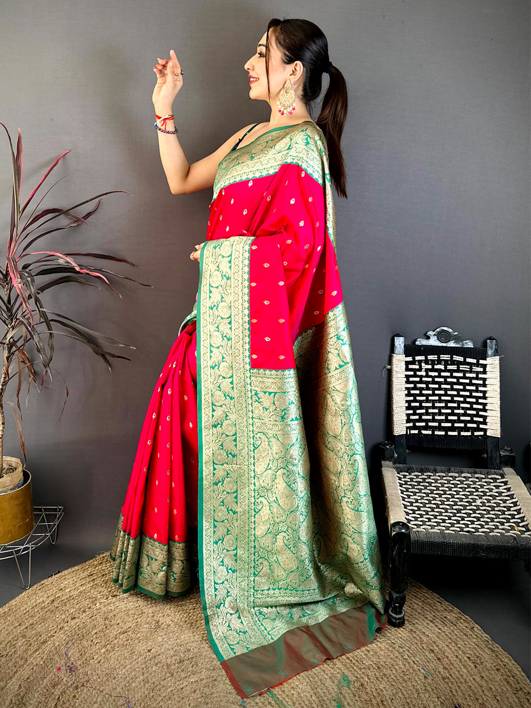 Close-up of bright pink silk saree with gold zari border and small gold motifs