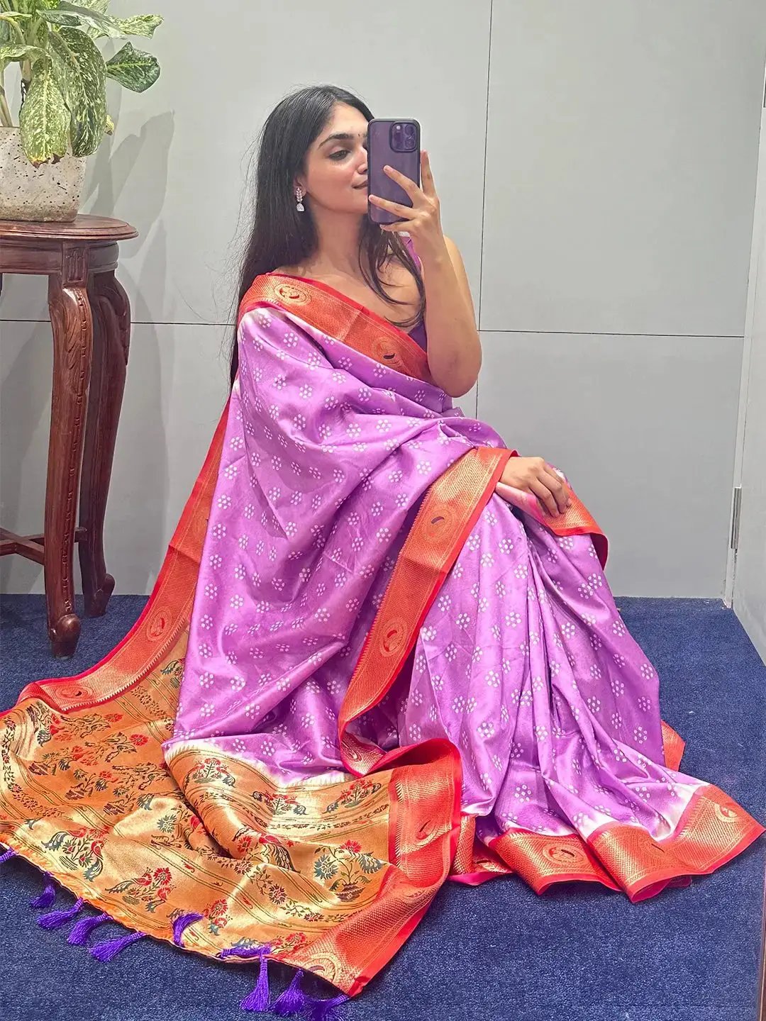 Purple Bandhani saree with intricate Paithani border, seated pose