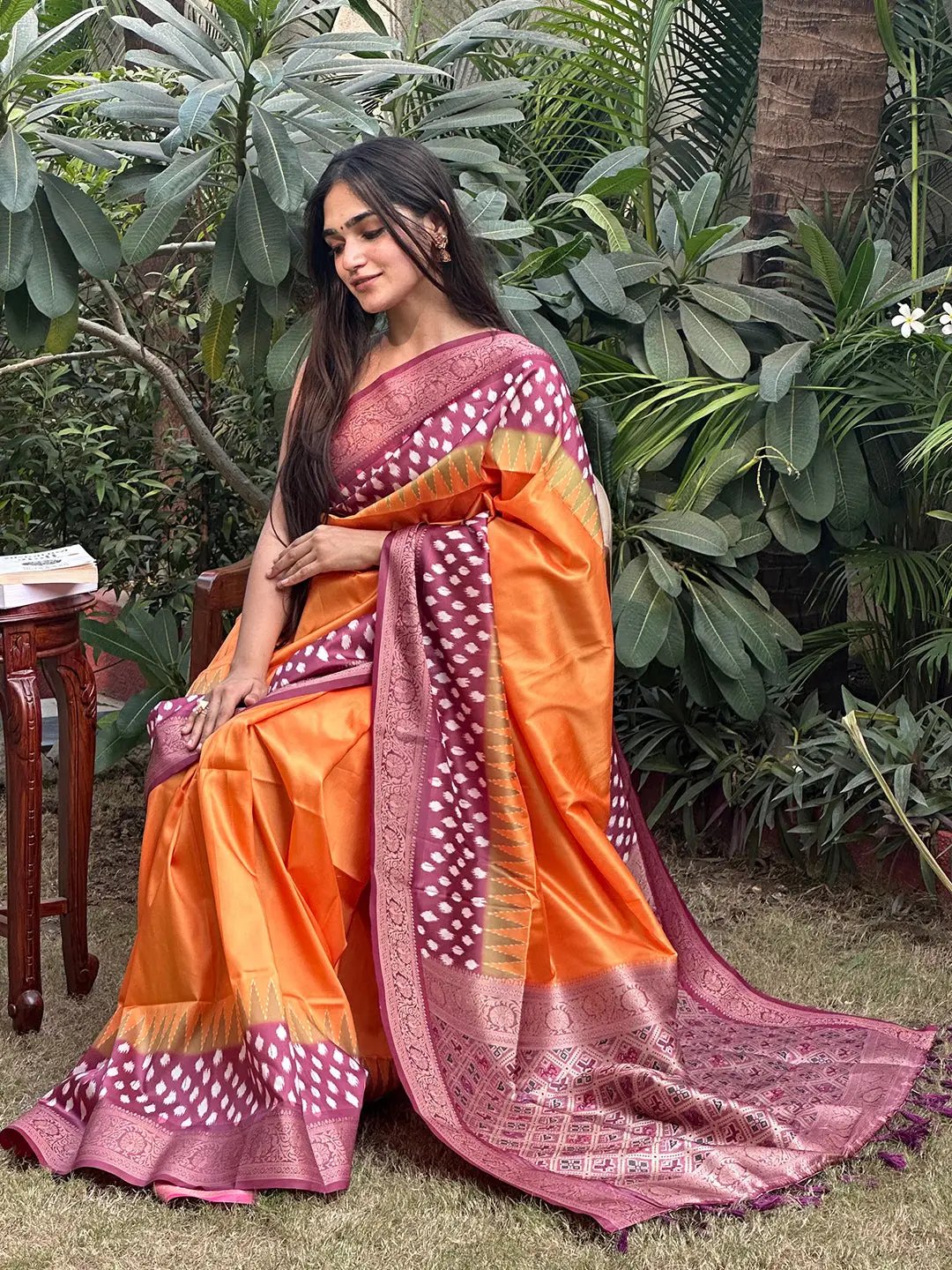 Orange Banarasi silk saree with Patola pallu, worn in garden