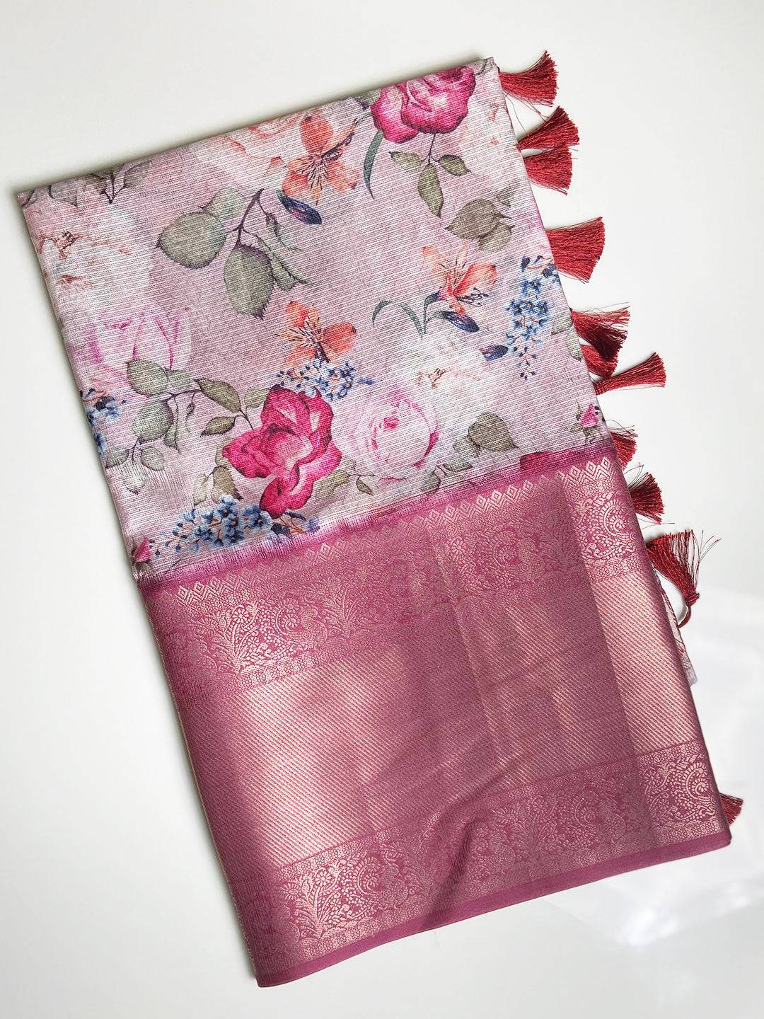 Folded pink Kota Doriya saree with floral design and tassels