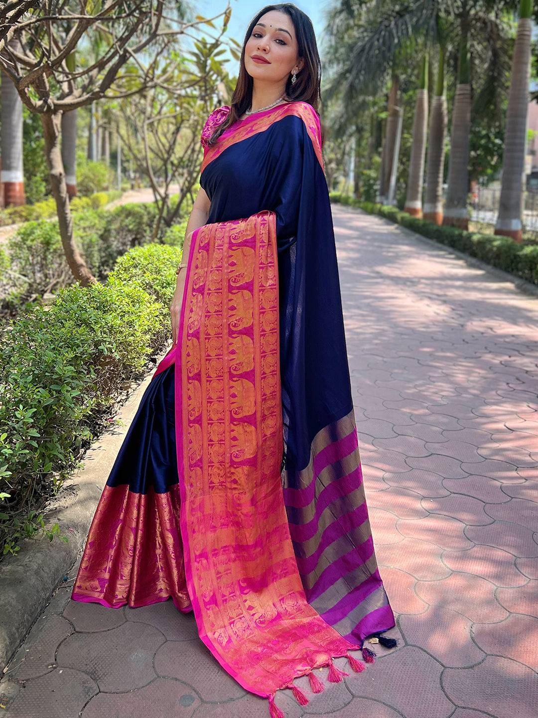 Model in navy Kanjivaram saree, showcasing pink woven patterns