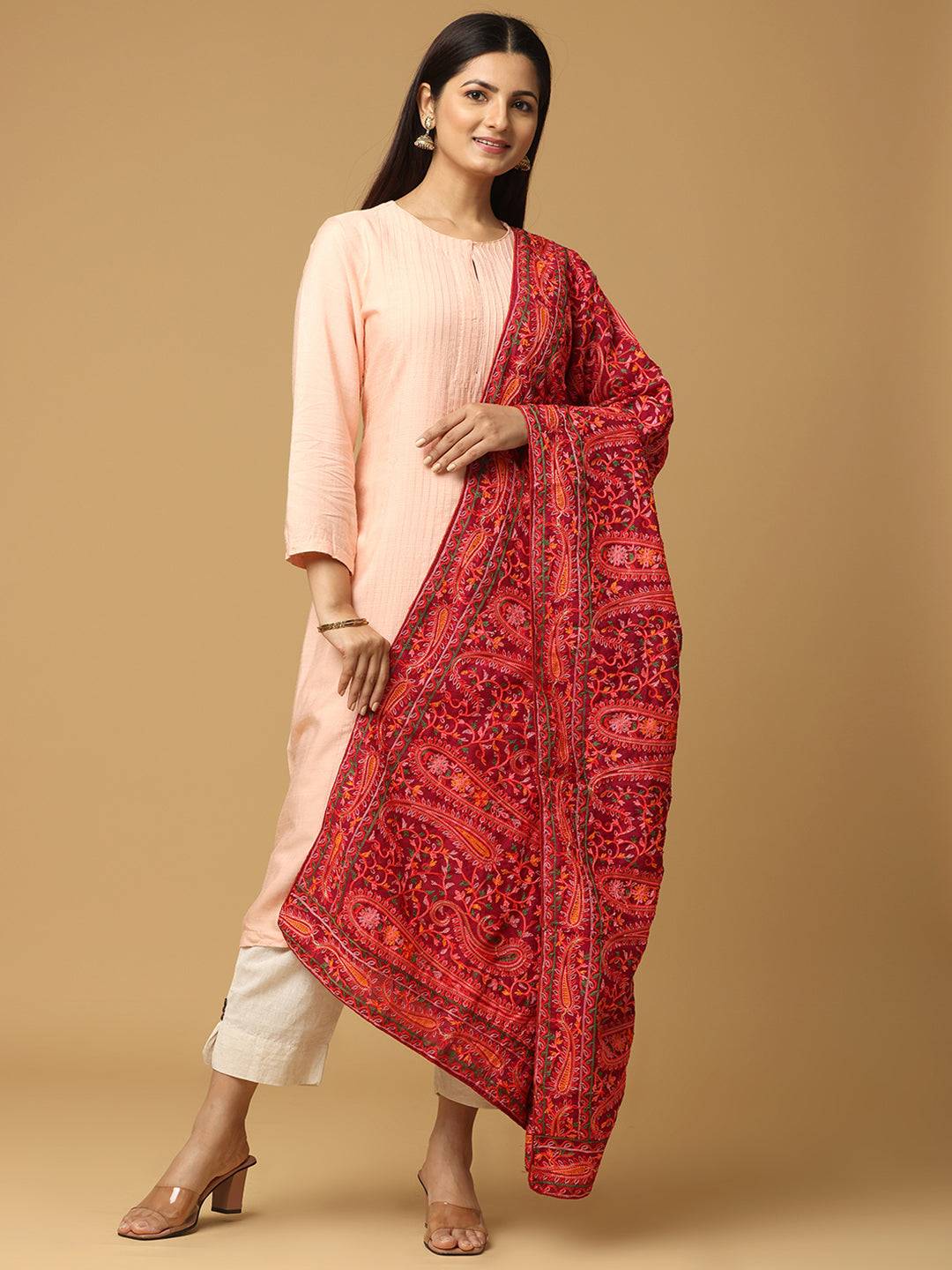 Model wearing red dupatta with vibrant threadwork.
