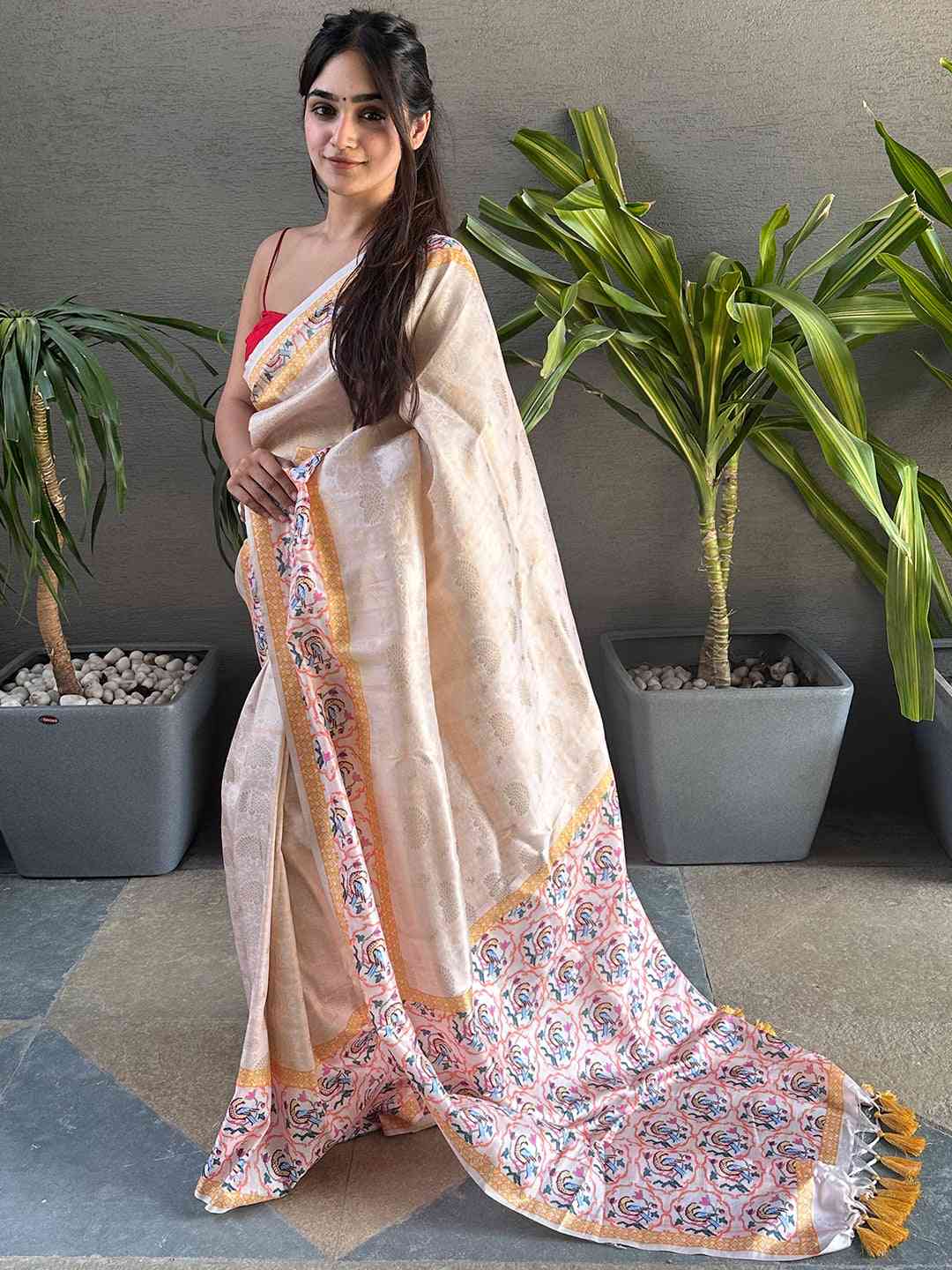 Woman wearing cream Kanjivaram saree with intricate Patola print