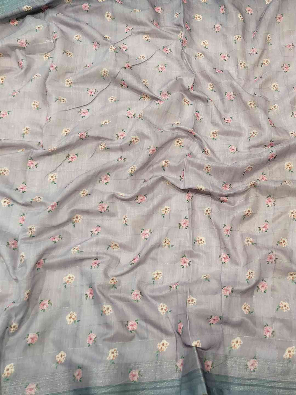 Close-up of grey saree fabric with floral and zari chex