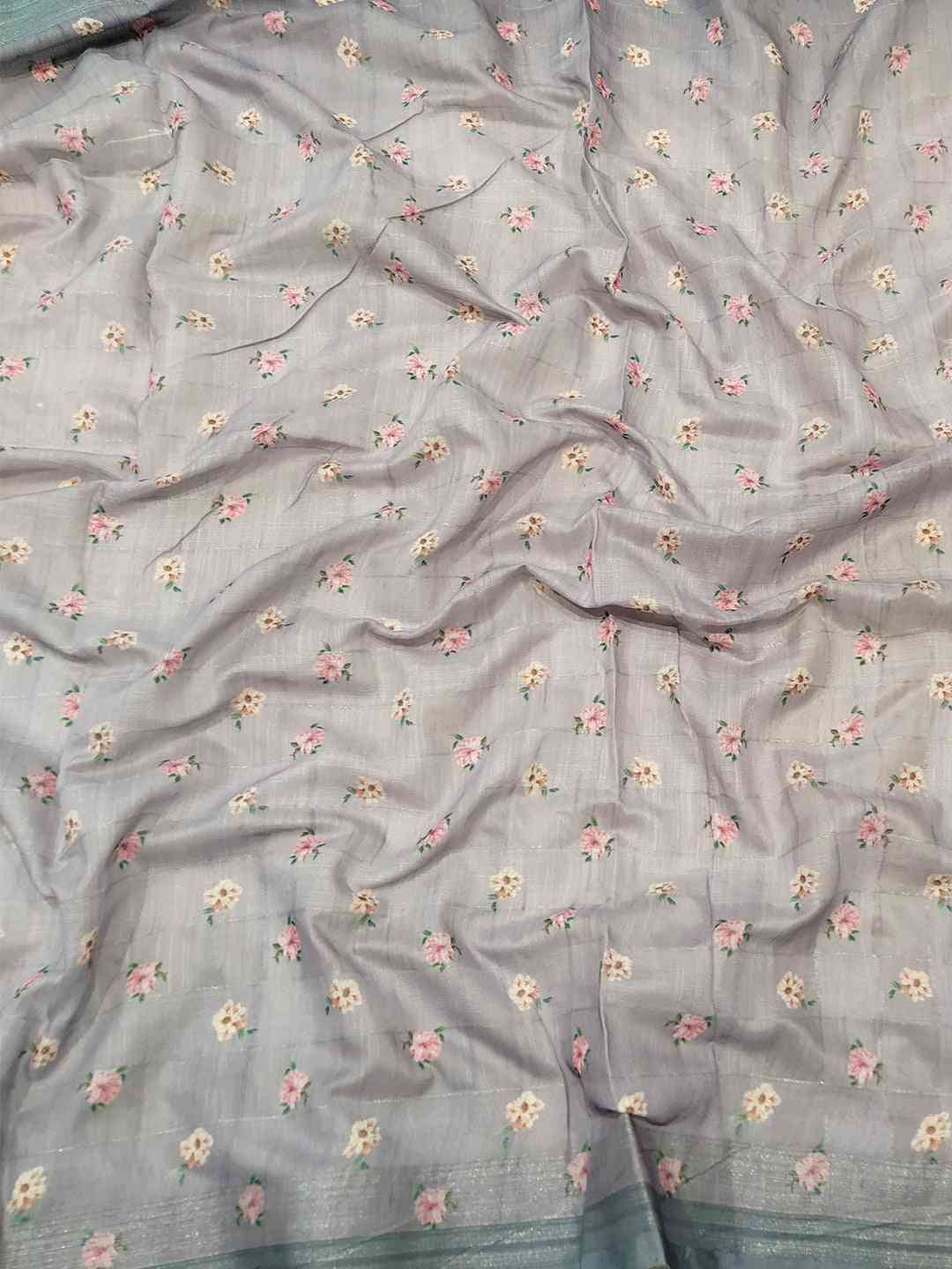Close-up of grey saree fabric with floral and zari chex