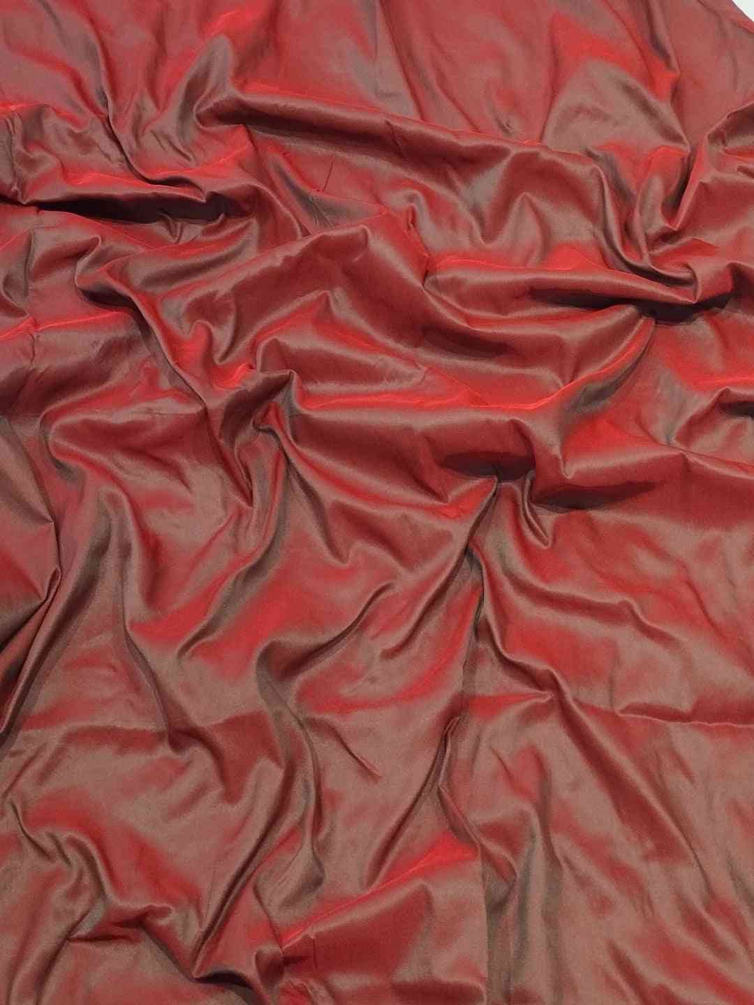 Close-up of red Paithani silk fabric with smooth texture