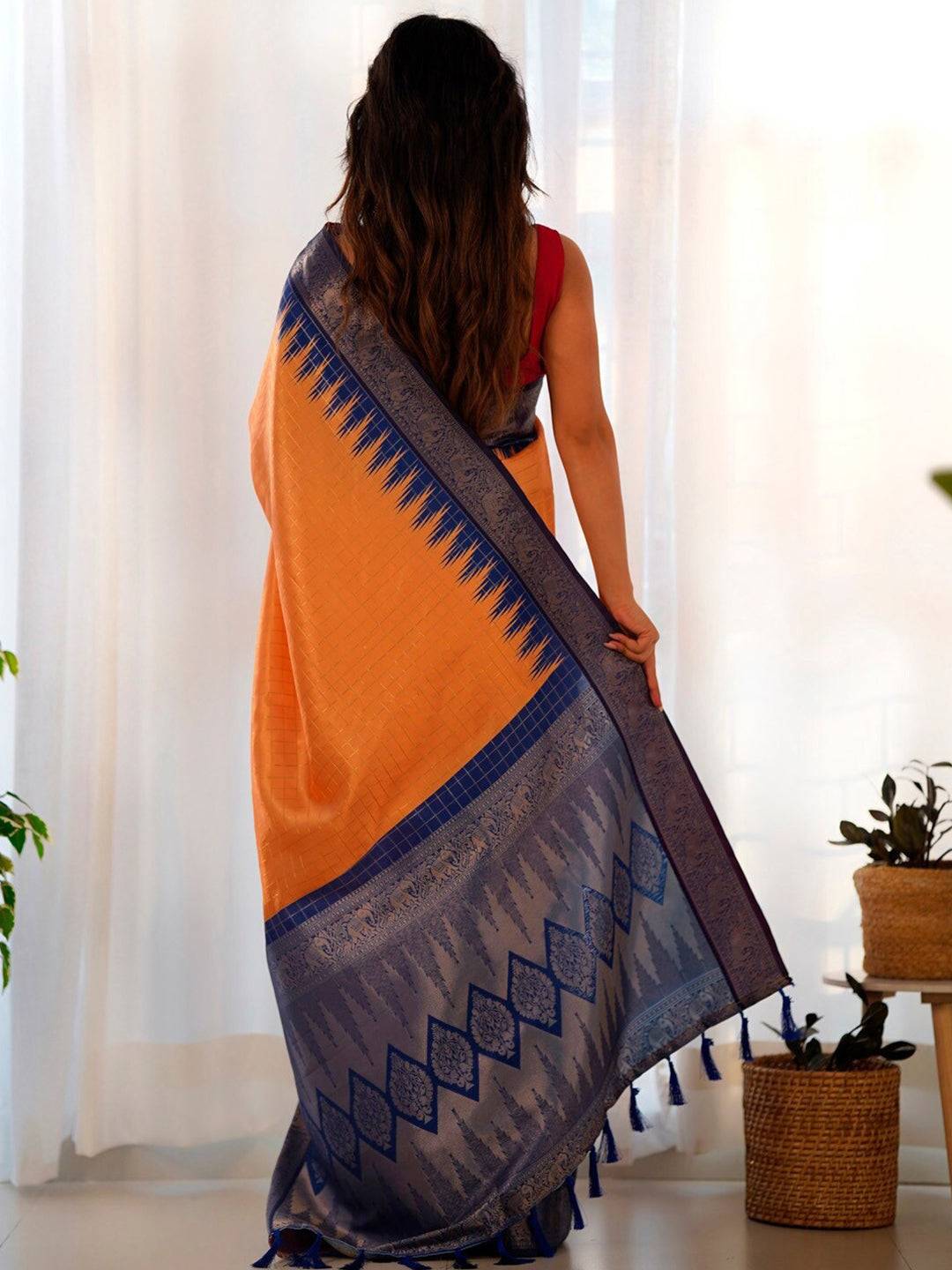 Back view of orange Banarasi saree with intricate blue design.