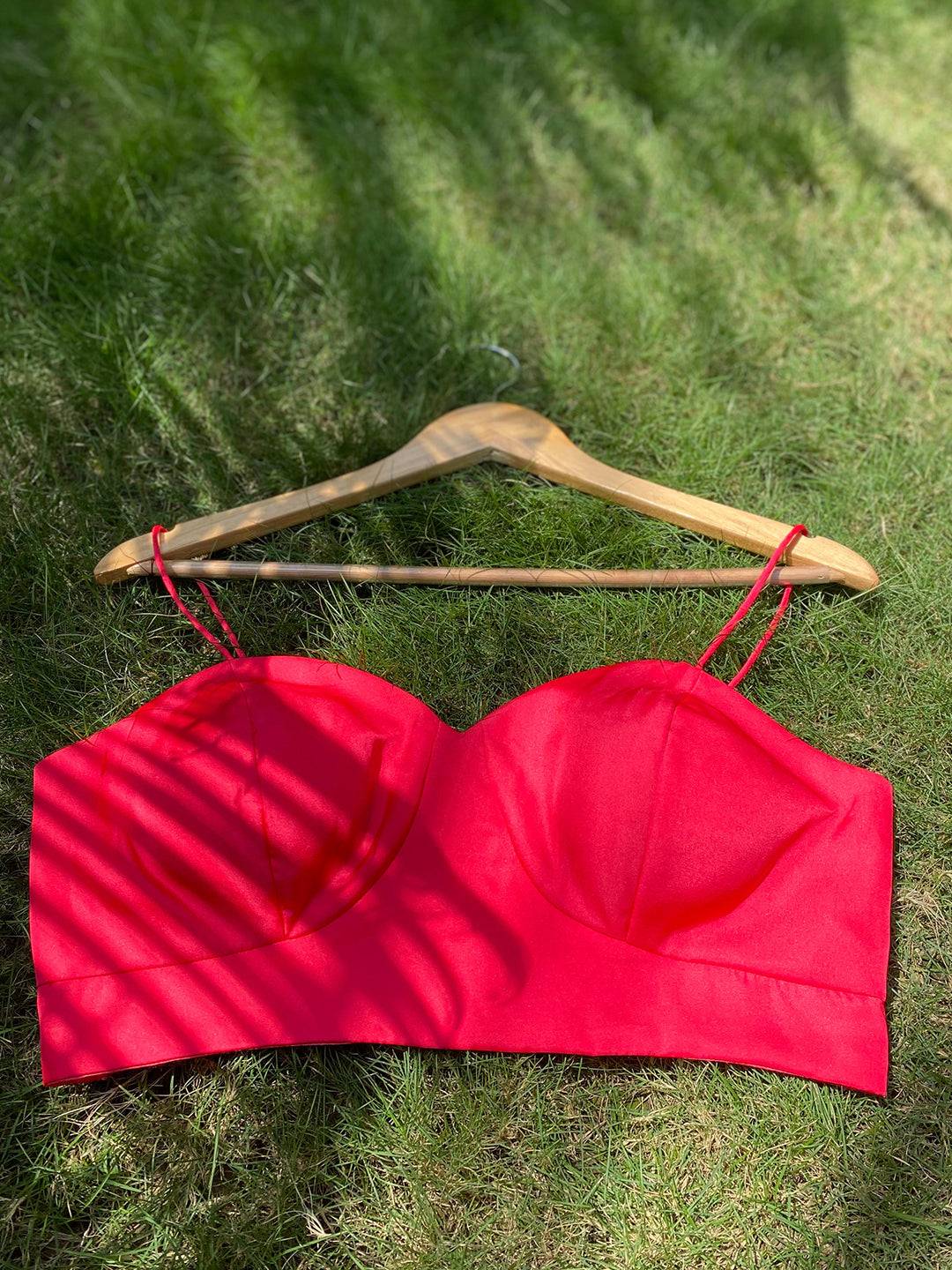 Red sleeveless blouse on hanger
