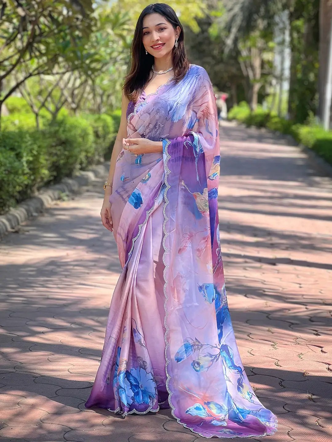 Full view of lavender floral print saree, model standing outdoors.