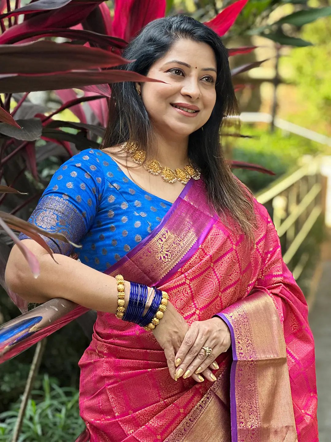 Woman in pink Kanjivaram saree with zari work outdoors