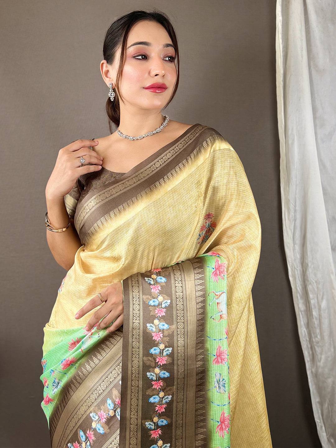 Elegant beige Kota saree with satin border and floral design.