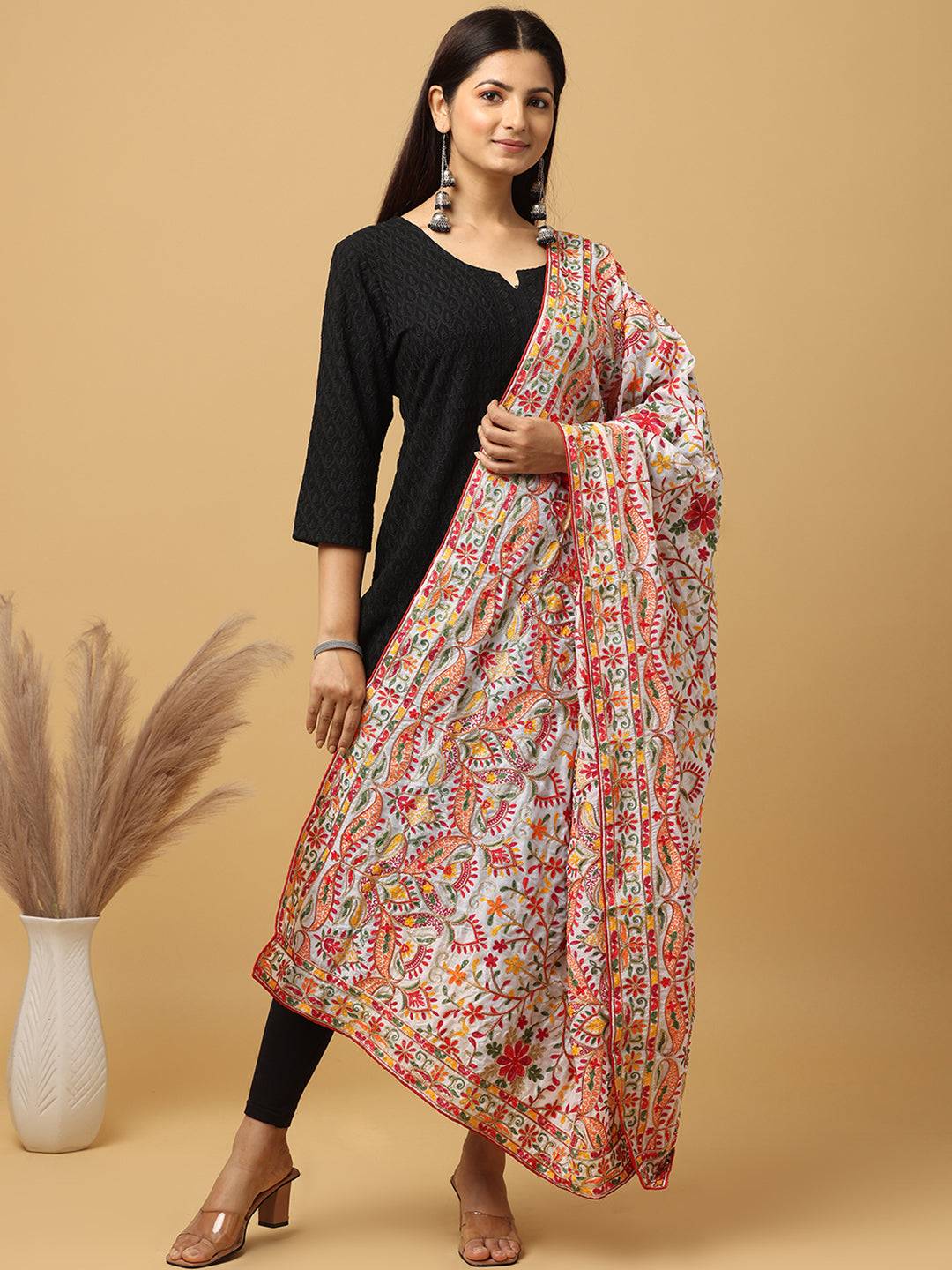 Model wearing white pashmina dupatta with vibrant embroidery.