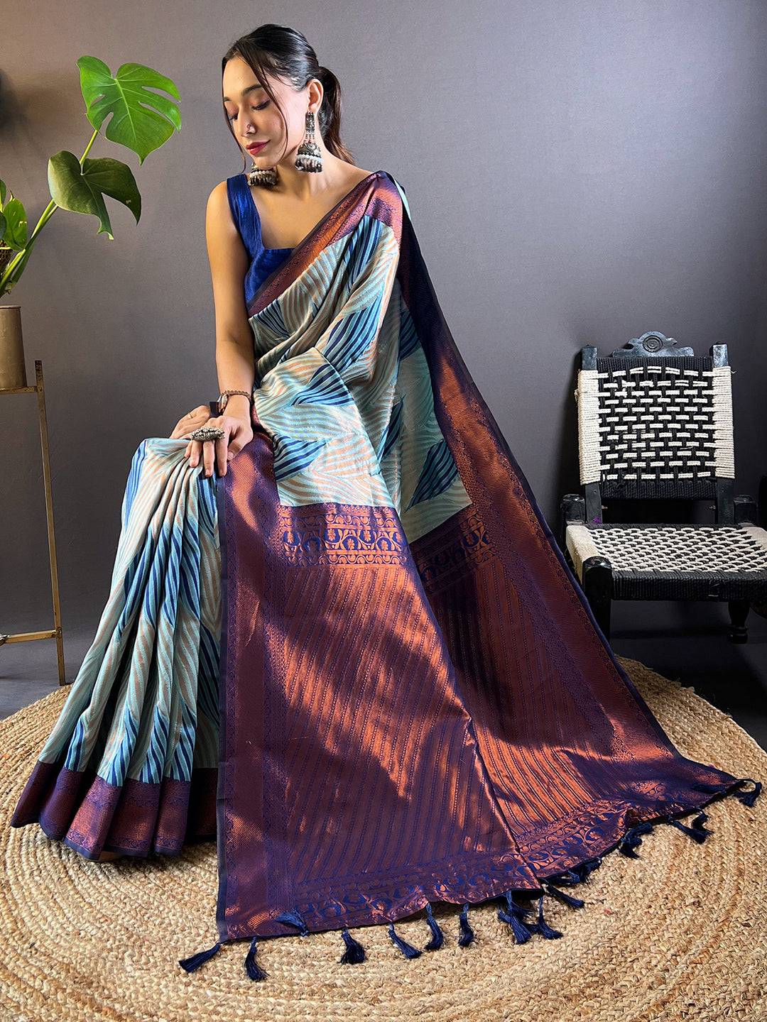 Model seated in sky blue Tussar silk Ikkat saree showcasing details.