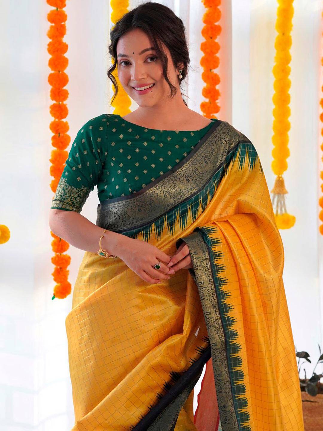Close-up of yellow Banarasi silk saree with green blouse design.