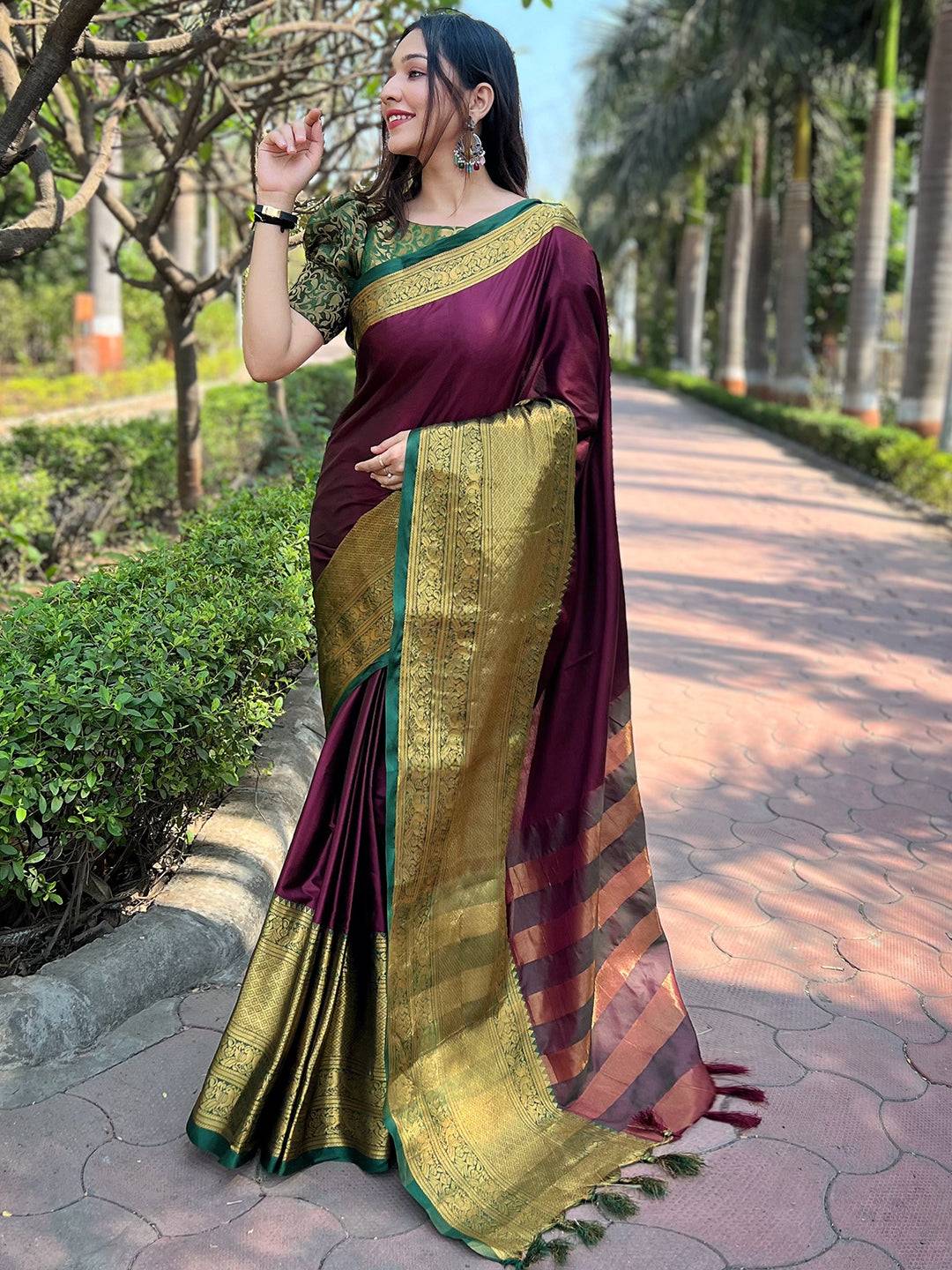Elegant wine Kanjivaram saree with gold pallu, outdoor scene