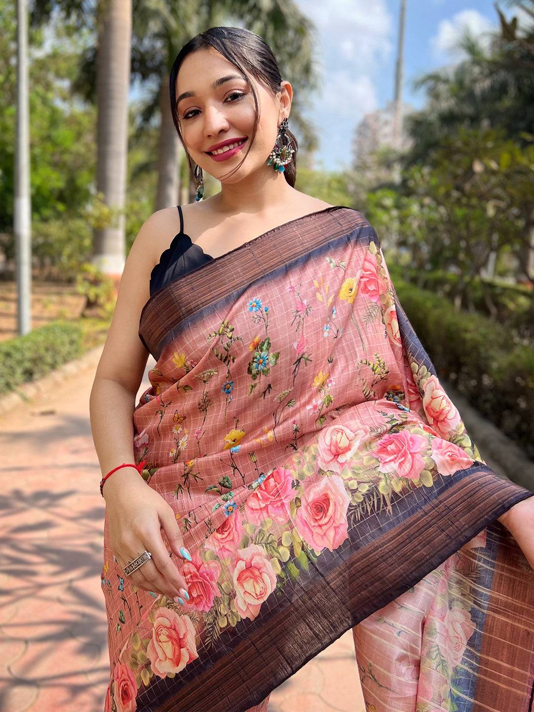 Woman wearing peach silk saree, intricate copper zari flowers