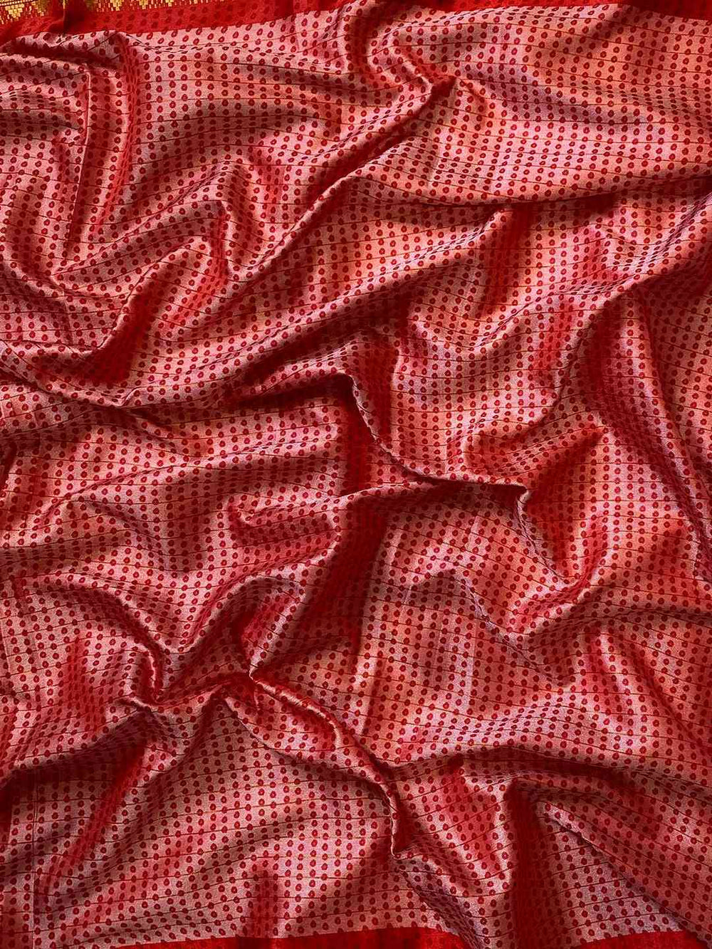 Close-up of red Bandhej print on soft silk fabric