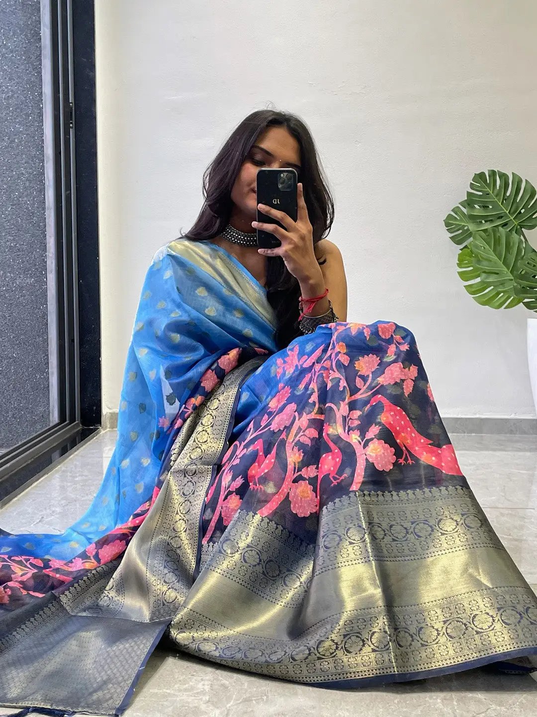Sitting pose with blue and pink Kalamkari printed saree.
