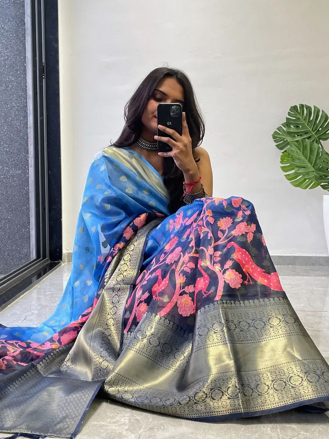 Sitting pose with blue and pink Kalamkari printed saree.