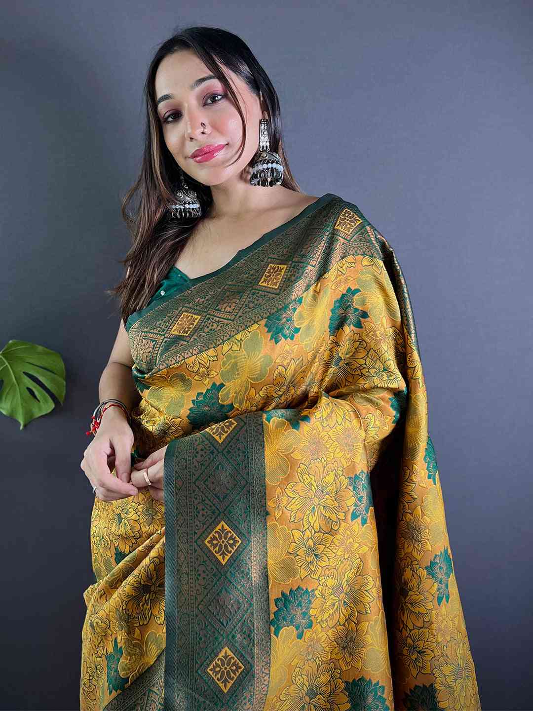 Mustard silk saree with floral butta weaving, worn by model.