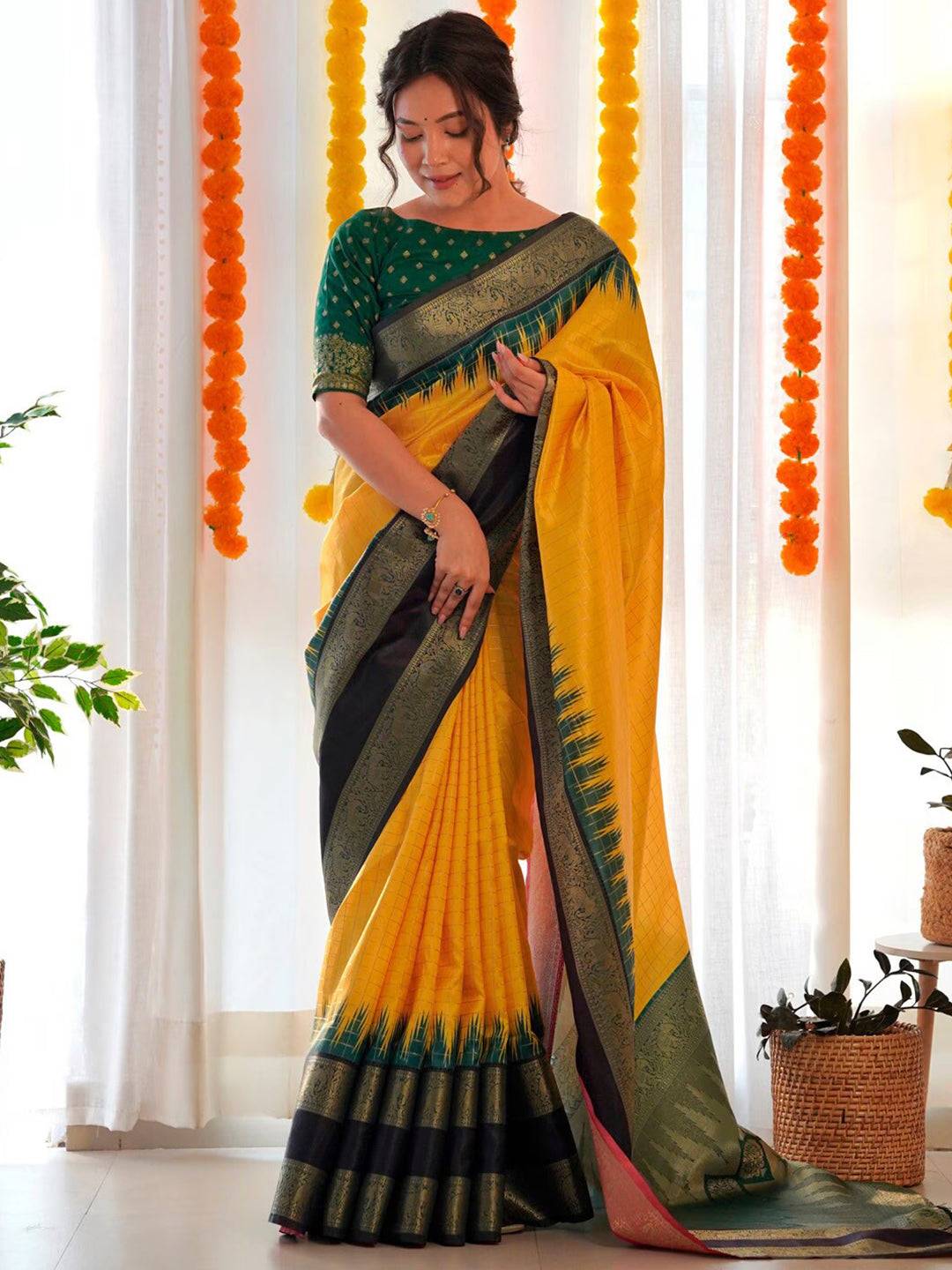 Elegant yellow Banarasi Gadwal saree with black and green border.
