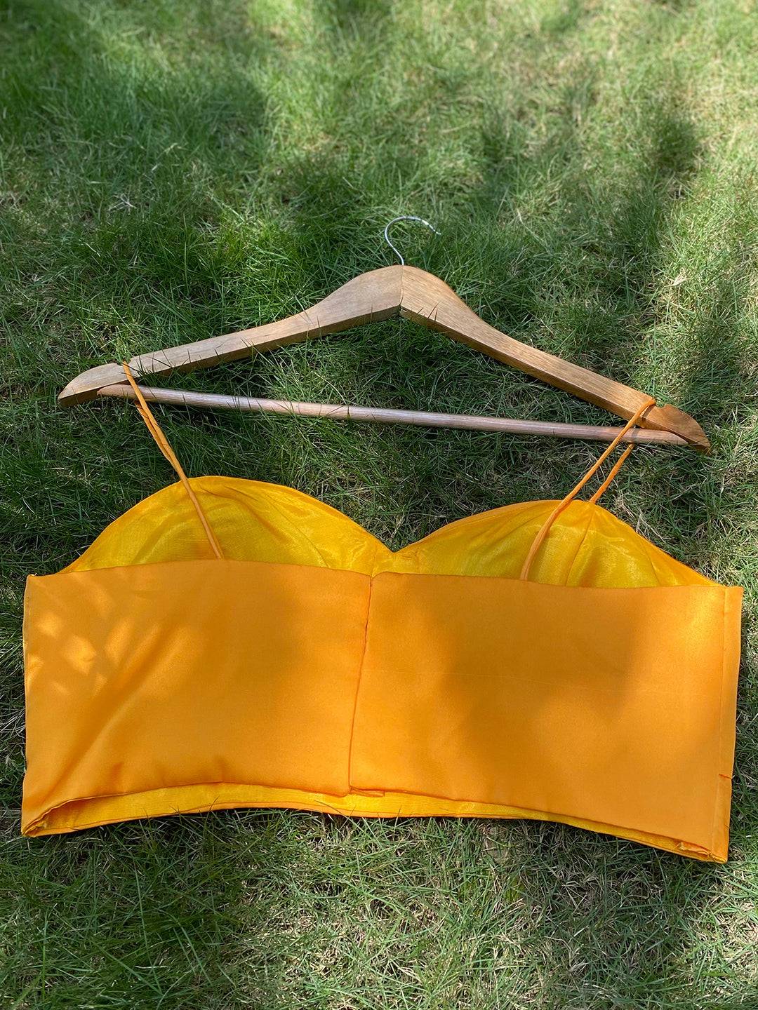 Back view of yellow spaghetti strap blouse on hanger