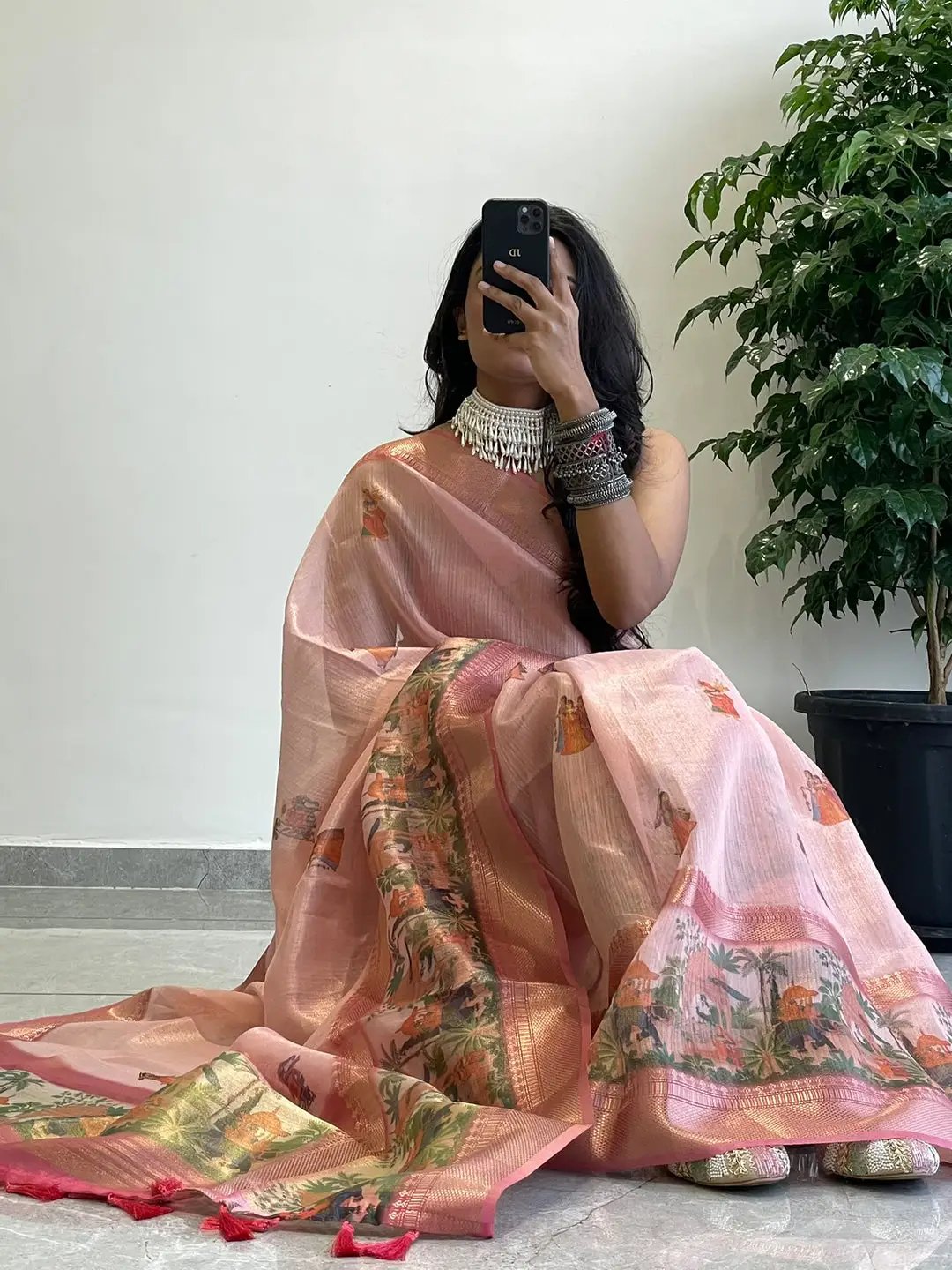 Elegant soft gold zari tissue saree with digital print, model seated.