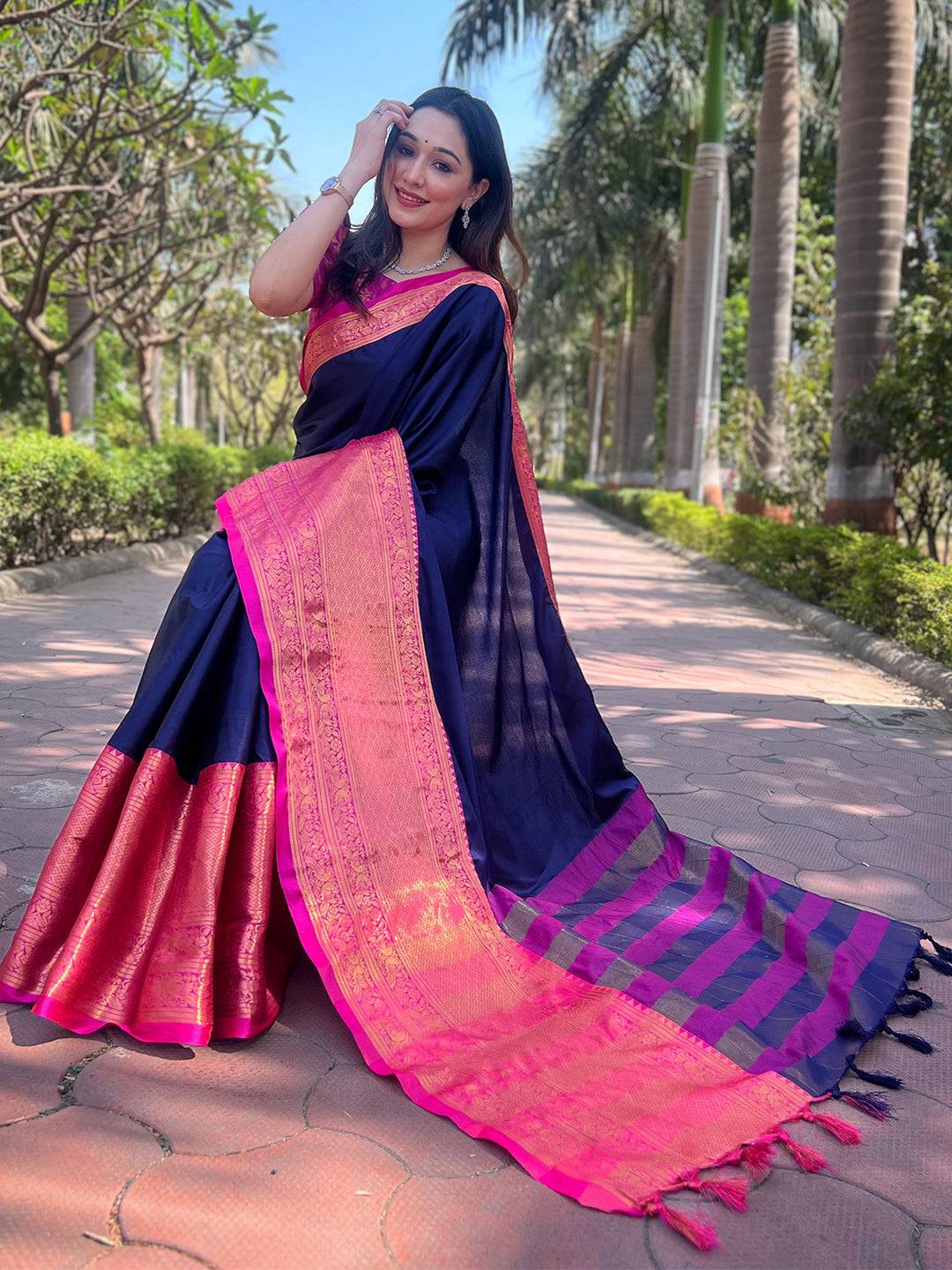 Model sitting in Navy Kanjivaram Saree with vibrant pink border