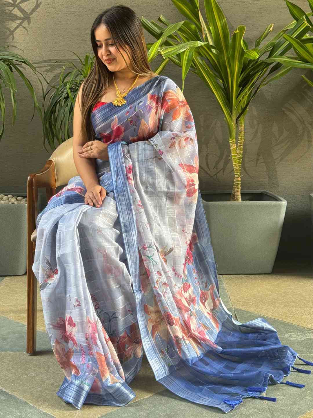 Stylish blue saree with floral print and zari chex design.