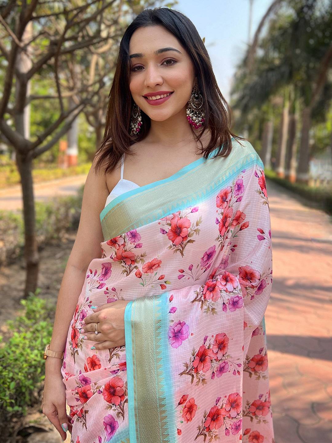 Smiling model in Pink Kota Saree with floral patterns