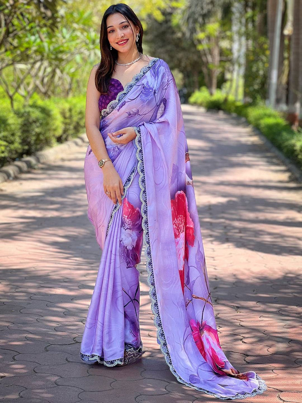 Model wearing purple floral print saree on a sunny path