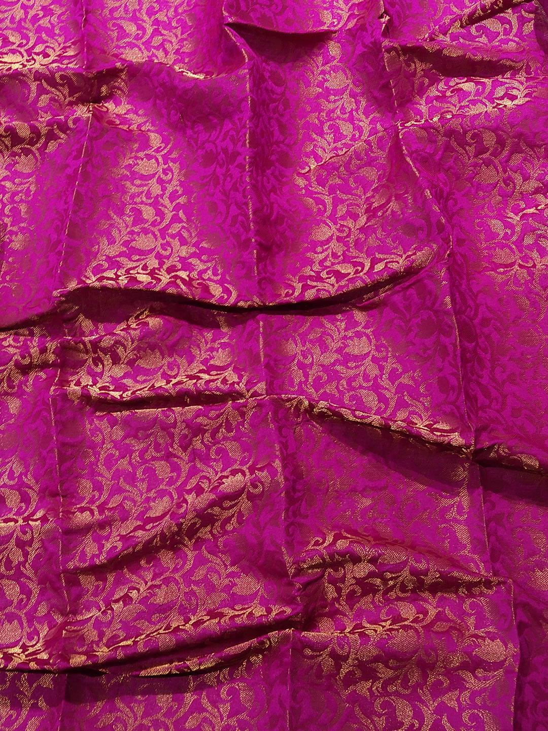 Close-up of pink brocade fabric with gold patterns
