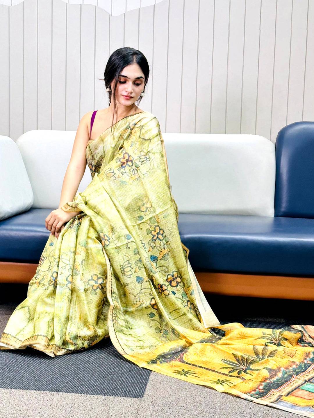 Woman seated wearing light green Kota Doriya silk saree with floral print